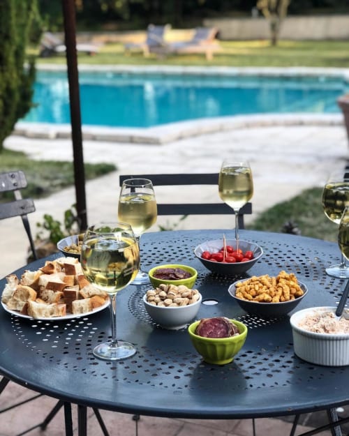 Poolside aperitif spread at Domaine Du Commandeur with white wine, appetizers and snacks overlooking the pool