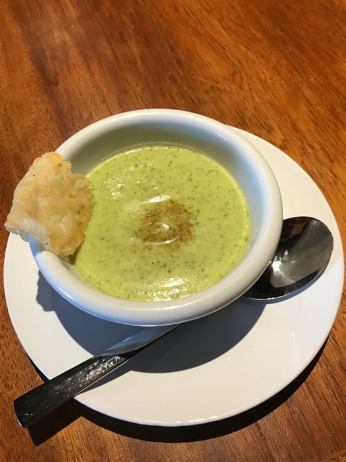 Creamy pistachio soup served at Le Pignié, a French bed and breakfast in Lescure-d'Albigeois, with crispy garnish and black