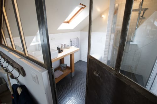 Modernes Dachgeschoss-Badezimmer im Le Loft du Matelot in Port-en-Bessin mit Dachfenster, Holzwaschbecken und weißen Fliesen