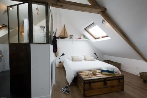 Gemütliches Dachzimmer bei Les Filles du Bord de Mer mit weißem Bett, Holzbalken, Dachfenster und maritimer Dekoration in Port-en-Bessin