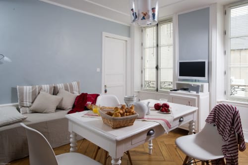 Lumineux séjour de l'établissement Les Filles du Bord de Mer avec canapé, table à manger, petit-déjeuner et baies vitrées