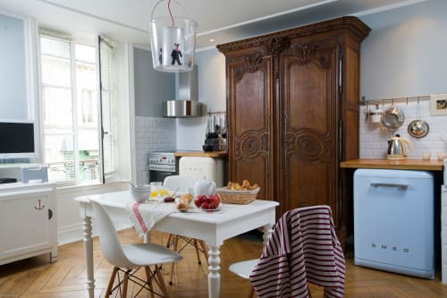 Charmant appartement cuisine aux Filles du Bord de Mer avec décor vintage, coin repas et réfrigérateur rétro bleu