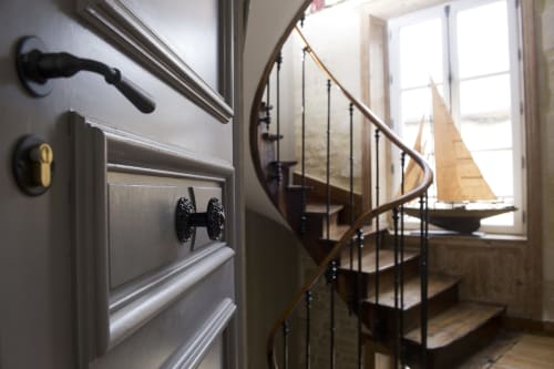 Élégant escalier en spirale avec rampe en bois et décoration de voilier dans l'appartement Les Filles du Bord de Mer.