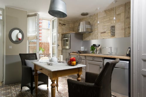 Cuisine-salle à manger moderne aux Filles du Bord de Mer avec table en bois, chaises noires, équipements inox et