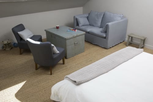 Chambre spacieuse avec coin salon aux Filles du Bord de Mer : lit, fauteuils gris, canapé et vue sur le port