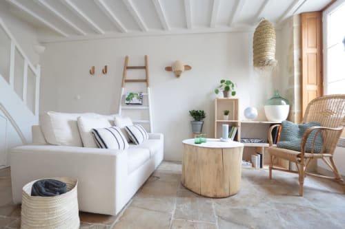 Séjour lumineux du cottage Poisson Nomade avec canapé blanc, touches de bois et vue sur mer aux Filles du Bord de Mer