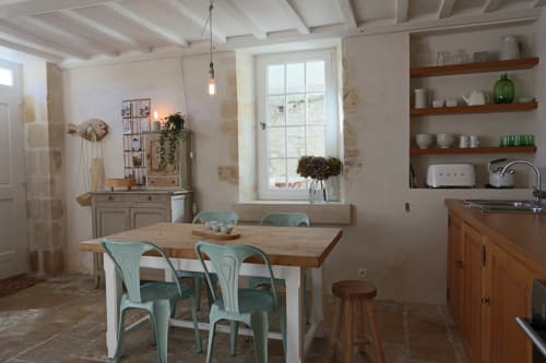 Salle à manger lumineuse avec table en bois, chaises turquoise et cuisine à Les Filles du Bord de Mer, Port-en-Bessin