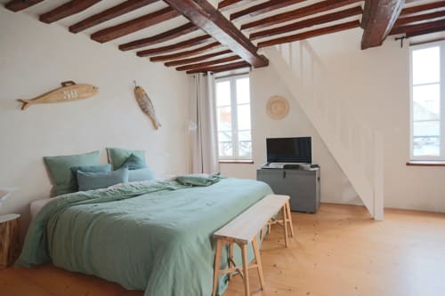 Chambre lumineuse au charme côtier avec literie vert sauge, poutres apparentes, parquet, vue sur mer et décoration nautique aux Îles