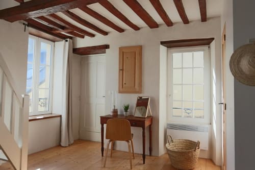Chambre lumineuse avec poutres apparentes, bureau et chaise en bois, panier tissé aux Filles du Bord de Mer