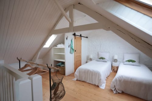 Chambre mansardée lumineuse avec deux lits jumeaux, poutres apparentes et velux au gîte Les Filles du Bord de Mer à Port-en-Bessin