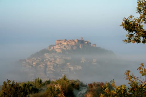 Medieval hilltop village of Cordes-sur-Ciel shrouded in morning mist, view from Le Pignié in Lescure-d'Albigeois