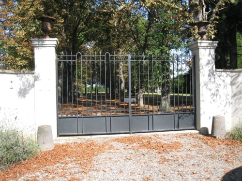 Élégants portails en fer forgé noir à l'entrée du Domaine de La Serita, un charmant gîte en Joze, France