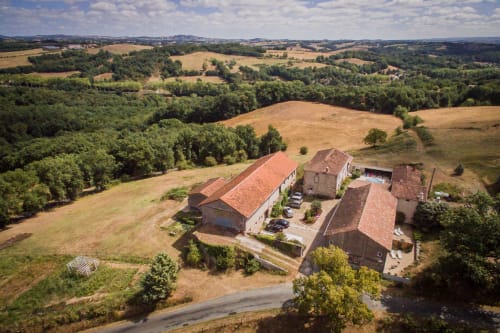 Vue aérienne du gîte Le Pignié nichée dans les collines vallonnées de Lescure-d'Albigeois, France, aux toits de terre cuite