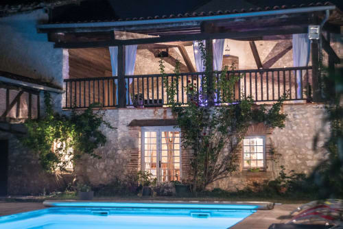 Le Pignié B&B pool with illuminated historic stone manor at night, Lescure-d'Albigeois