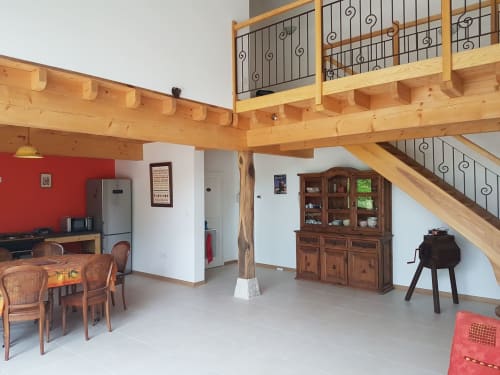 Espace de vie loft moderne à la Ferme Passion B&B avec poutres en bois apparent, mur d'accent rouge et mobilier rustique