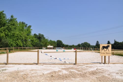 Carrière équestre à Ferme Passion avec obstacles, barrières en bois et champs verts en France rurale
