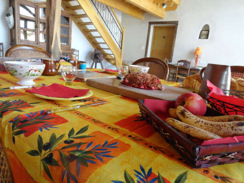 Table colorée à la Ferme Passion avec fruits frais, vin et charme rustique de la campagne française