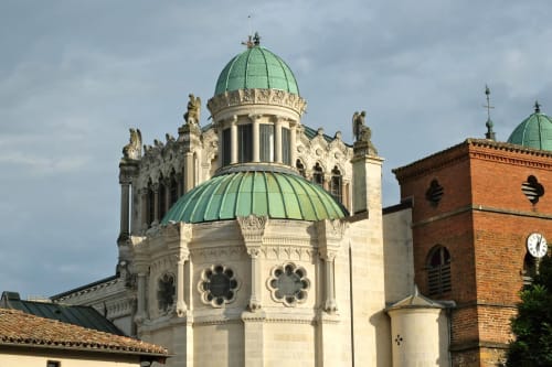 Cathédrale ornée avec dôme et toit en cuivre vert, façade en pierre blanche près de l'auberge Ferme Passion