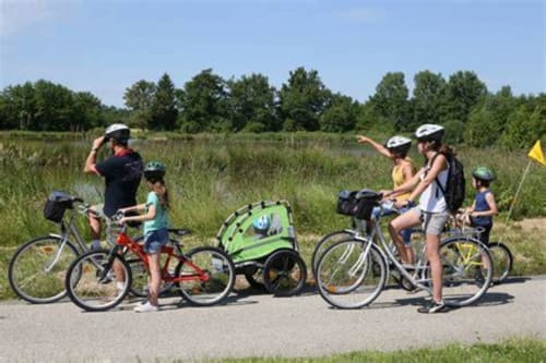 Groupe familial à vélo à la Ferme Passion B&B à Saint-Trivier-sur-Moignans, France, avec paysage rural en arrière-plan