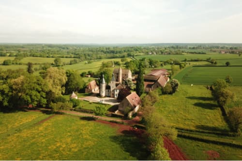 Château De Clusors, a French château in Saint-Menoux surrounded by lush green fields and countryside estates.