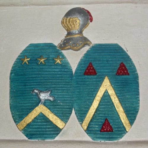 Blason héraldique avec écu bleu-vert, chevrons dorés et triangles rouges, heaume de chevalier au Château de Clusors