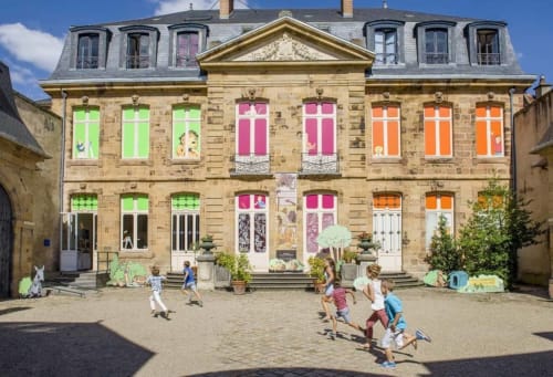 Château De Clusors in St Menoux features colorful windows and courtyard where children play