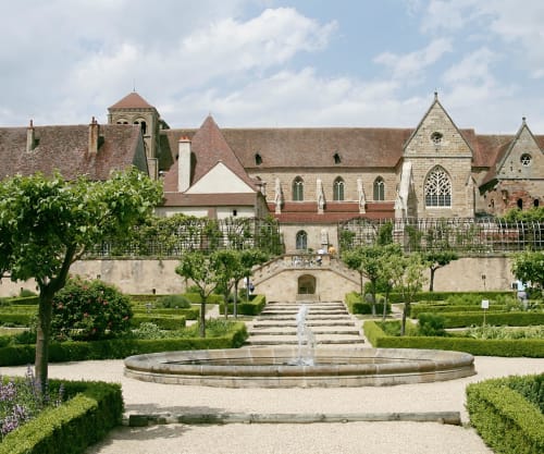 Château De Clusors in Saint-Ménoux with formal gardens, fountain, and historic stone buildings