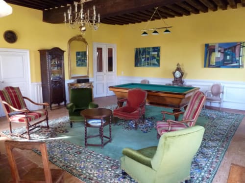 Sala de juegos del Château De Clusors con mesa de billar, muebles vintage y paredes amarillas en ST MENOUX