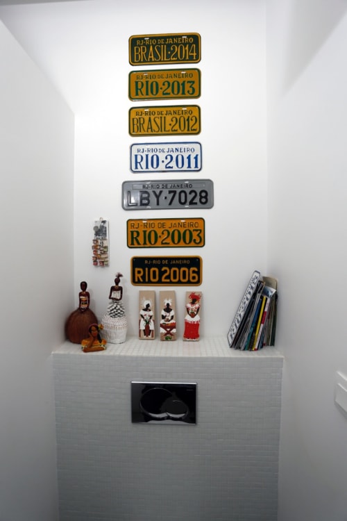 Étagère blanche exposant des plaques minéralogiques de Rio de Janeiro et des souvenirs culturels brésiliens dans la Sala Prainha Da Barra du Cote Et