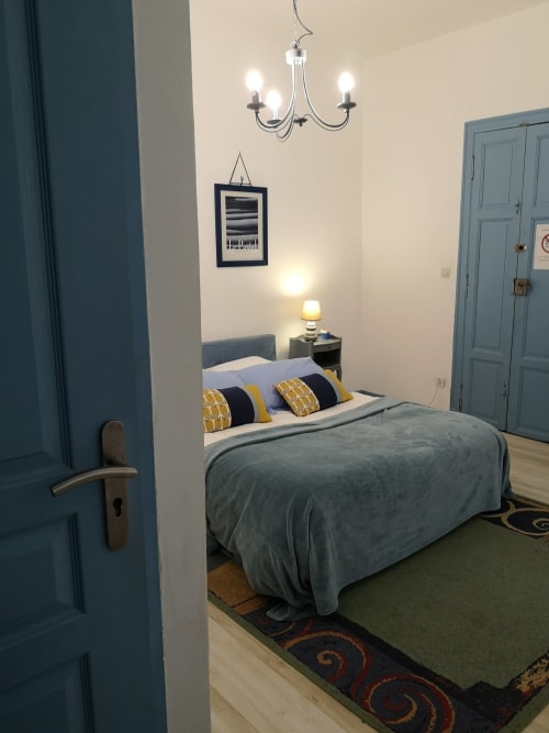 Chambre bleue moderne à la maison d'hôtes L'affable aux Cammazes avec portes bleues, lustre et coussins jaune et noir