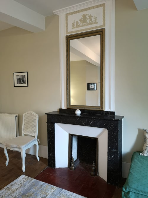 Cheminée élégante avec miroir orné et imposte décorative au gîte L'affable aux Cammazes