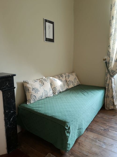 Chambre douillette à la L'affable B&B aux Cammazes avec lit vert, oreillers et rideaux à motifs de feuilles