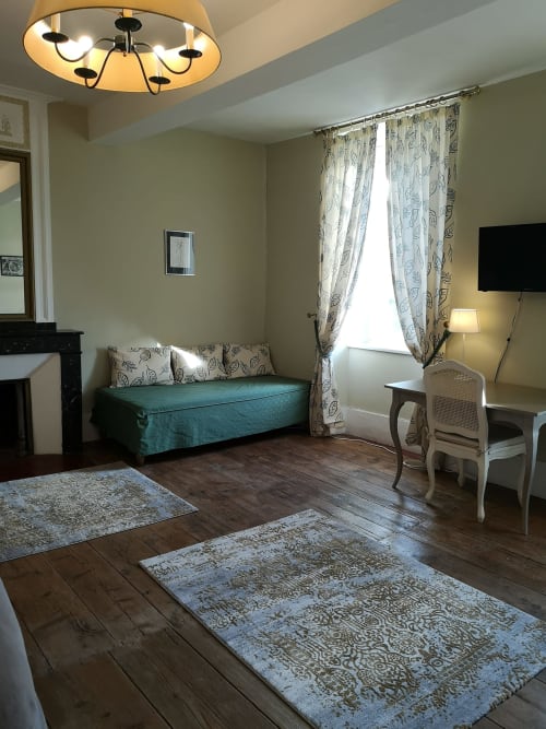 Chambre double beige à L'affable B&B aux Cammazes avec lit de jour turquoise, bureau, TV et vue sur le jardin