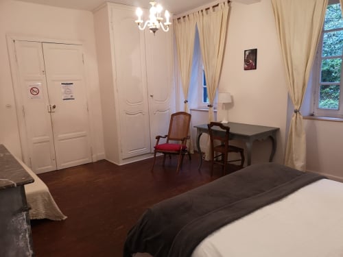 Chambre double spacieuse à L'affable B&B à Les Cammazes avec bureau, chaise, armoire, vue sur jardin et planchers en bois dur