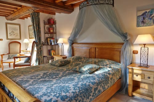 Lit à baldaquin élégant à la Chambre du Meunier du Moulin d'Ajon, chambres d'hôtes avec vue sur le jardin en Normandie
