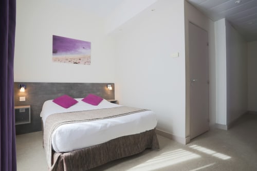 Camera doppia moderna all'Hôtel De La Fontaine di Nizza con accenti viola, decorazione ispirata al giardino e arredi contemporanei