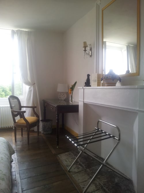 Chambre Marie du Domaine De Puyrousse avec coiffeuse, miroir, chaise et vue sur le jardin à Villetoureix
