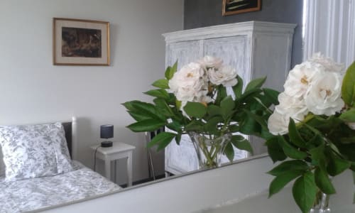 Chambre élégante au Domaine De Puyrousse avec pivoines blanches, vue sur le jardin et mobilier classique à Villetoureix