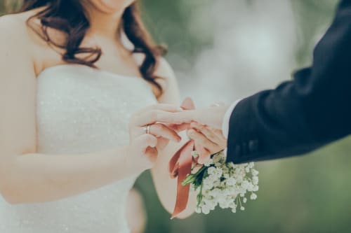 Les mariés échangent les alliances avec un bouquet de fleurs blanches au domaine de Puyrousse à Villetoureix, France