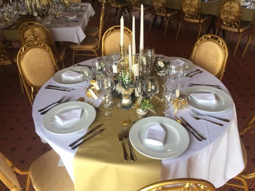 Table élégamment dressée à La Ferme Du Grand Air avec linges blancs, candélabres dorés et couverts raffinés