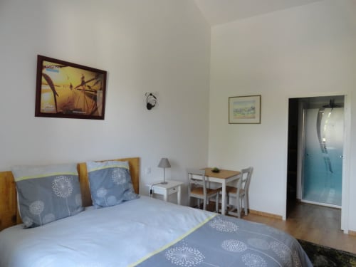 Chambre Dombes à la Ferme Passion : chambre lumineuse avec literie bleue, coin repas et vue sur le jardin