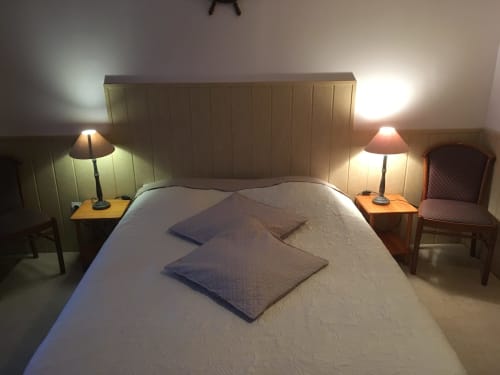 Chambre douillette à La Ferme Du Grand Air B&B à Fiennes avec lit blanc, deux oreillers bleus, lampes de chevet, tables de nuit en bois et
