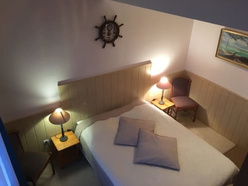 Chambre douillette à La Ferme Du Grand Air à Fiennes avec lit, lampes, décoration roue de bateau et boiseries