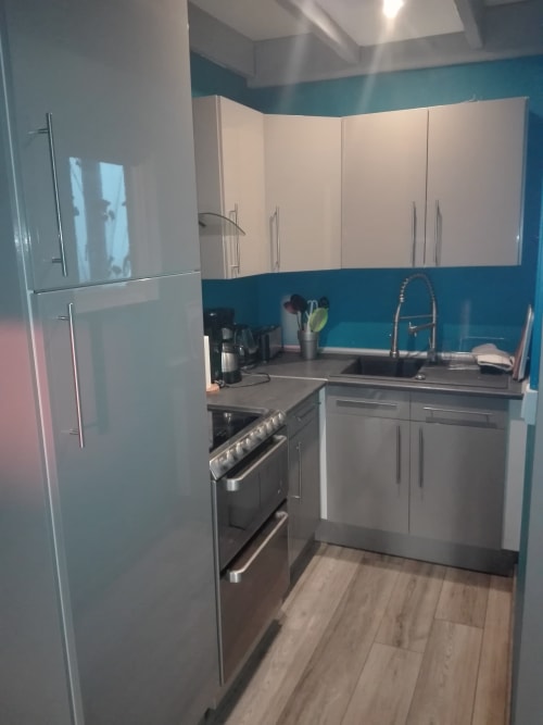 Cuisine moderne du gîte Le Gîte à La Ferme Du Grand Air, Fiennes, avec murs turquoise, appareils inox et