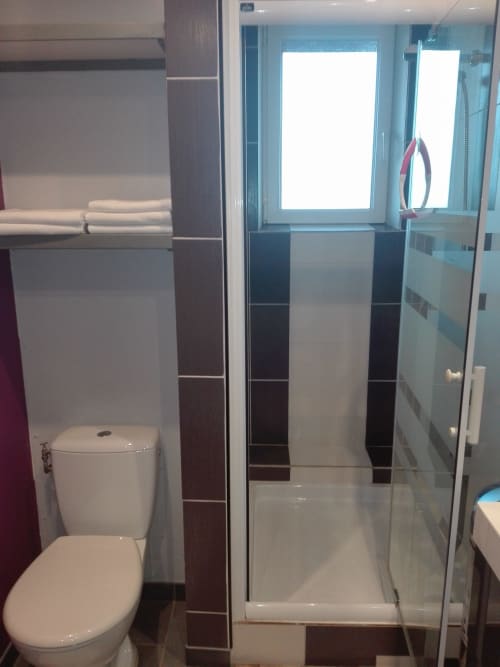 Salle de bain contemporaine du gîte Le Gîte à La Ferme Du Grand Air avec douche vitrée, toilettes, carrelage foncé et