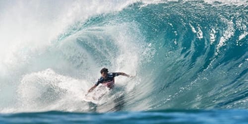 Surfeur chevauchant une grande vague turquoise près de Biarritz, France