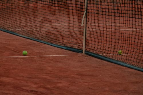 Court de tennis à Domaine De Puyrousse à Villetoureix avec surface en terre battue et filet rouge