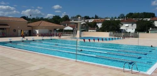 Piscine olympique au Domaine De Puyrousse à Villetoureix, France, avec couloirs de nage et terrasse ensoleillée.