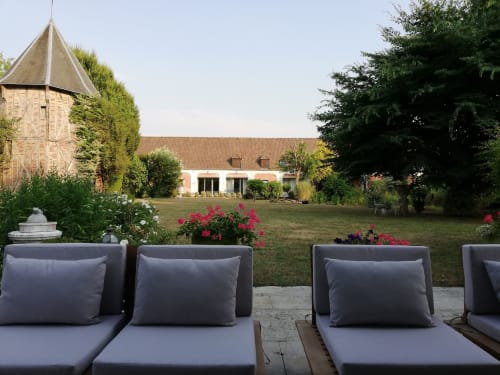 Des chaises longues grises dominent les jardins soignés de La Cour d'Hortense, un charmant bed and breakfast à Sailly-Flibeaucourt,