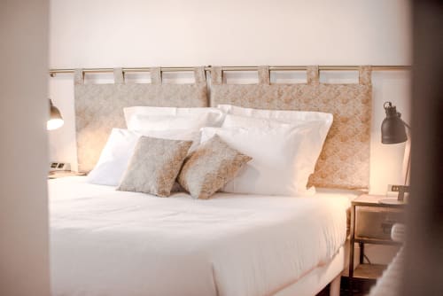 Elegantes Schlafzimmer im Le Pignié B&B in Lescure-d'Albigeois mit weißer Bettwäsche, gemustertem Kopfteil und warmem Licht